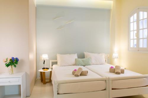 a bedroom with a white bed with two pillows on it at Bellevue Suites in Agios Nikolaos