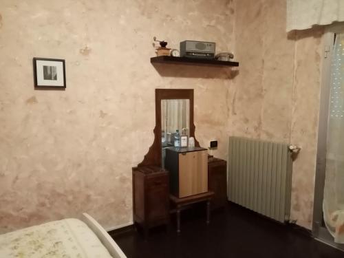 a room with a table and a mirror and a radiator at Dallapia in Santa Maria del Piano