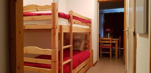 a room with two bunk beds with a table at Chez Angie et Fanny - Résidence l'Horizon Blanc in La Joue du Loup