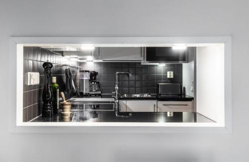 a kitchen with a sink and a microwave at 2ndhomes Luxury Kamppi Center Apartment with Sauna and Terrace in Helsinki