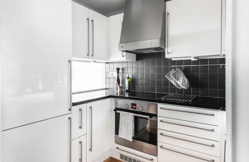 een keuken met witte kasten en een fornuis met oven bij 2ndhomes Luxury Kamppi Center Apartment with Sauna and Terrace in Helsinki