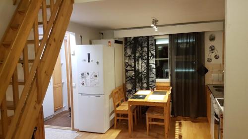eine Küche mit einem weißen Kühlschrank und einem Tisch in der Unterkunft Ojuspirtti 26B Levi in Levi