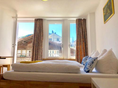 a bed in a room with a large window at central beauty scenery apartment in Interlaken