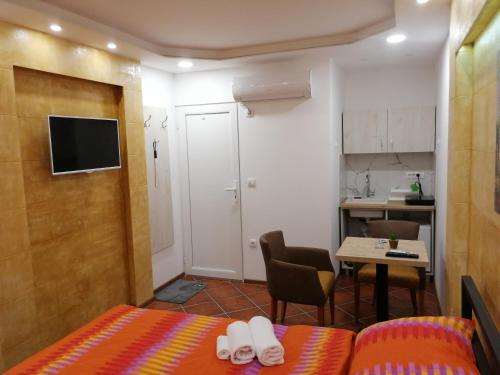 a small room with a bed and a table and a kitchen at Vila Violeta in Šabac