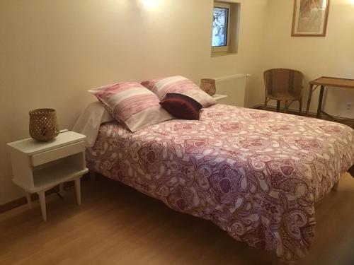 a bedroom with a bed with pillows and a table at Mas Graffouil in Prats-de-Mollo-la-Preste