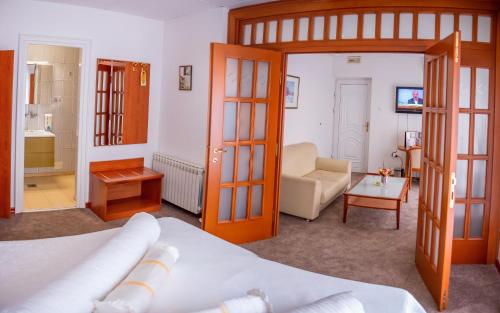 um quarto com uma cama e uma sala de estar em Hotel Integra em Doboj