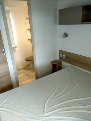 レ・マトゥにあるmobilhome 433 la Palmyreのベッドルーム(白いベッド1台付)、バスルーム