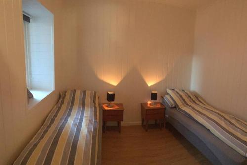 a bedroom with two beds and two tables with lamps at Balestrand Fjordapartments Holmen 19A in Balestrand