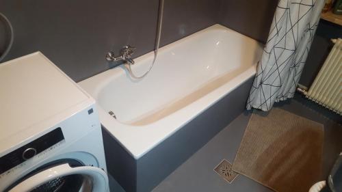 a bath tub in a bathroom with a washing machine at SonnenApartment in Lana