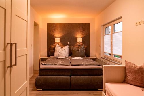 a bedroom with a bed with two lamps and a window at Ferienhaus Glücksmoment in Blankenburg