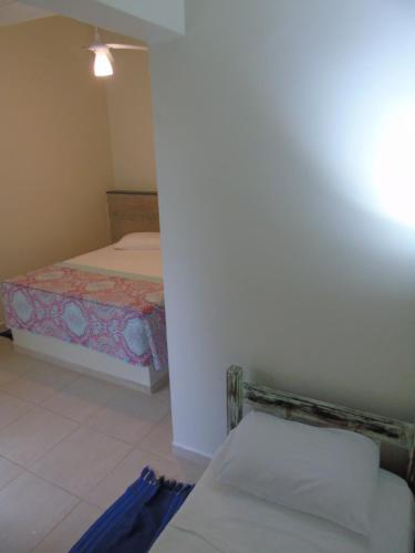 a small room with a bed and a room with at Pousada Sobre as Pedras in Itanhaém