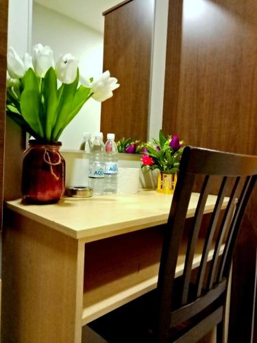 a desk with a vase of flowers on it at Eazy Hotel at Ampang in Batu Empat