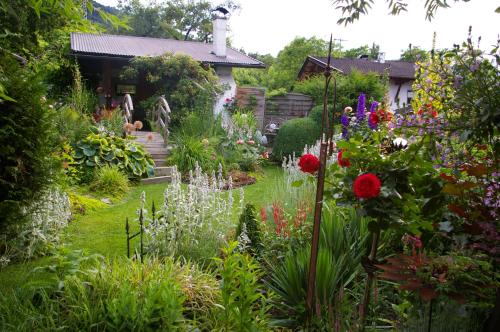 a garden with colorful flowers in front of a house at Thalerhof in Roppen