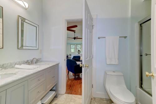 a white bathroom with a toilet and a sink at The Cottage at DuPont in Charleston