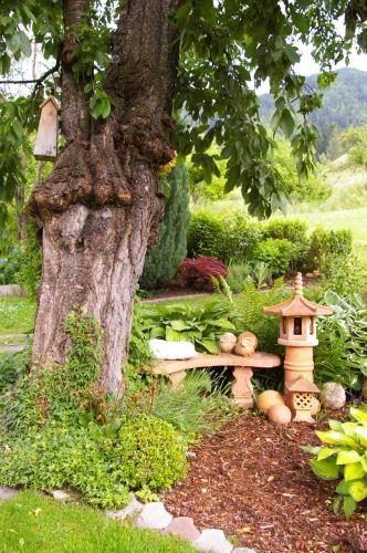a garden with a bench under a tree at Thalerhof in Roppen
