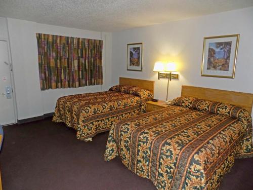 a hotel room with two beds and two lamps at Plaza Inn in Topeka