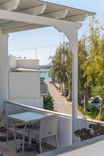 a patio with a table and chairs and a view of the water at Cyclades Studios in Parikia