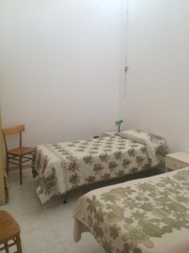 a bedroom with two beds and a chair at Casa Calanave 1 in Ventotene
