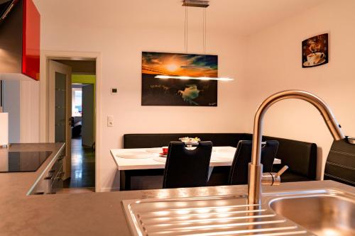 a kitchen and dining room with a table and a sink at Ferienhaus Glücksmoment in Blankenburg