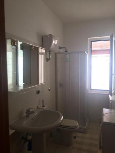 uma casa de banho com um lavatório, um WC e uma janela. em Casa Calanave 1 em Ventotene