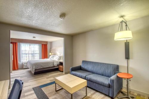 a living room with a couch and a bed at Holiday Inn Express Hotel & Suites Milwaukee Airport by IHG in Milwaukee