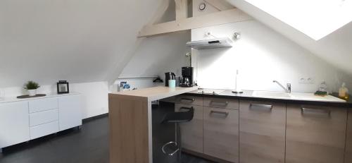 une cuisine avec des armoires blanches et un évier dans l'établissement Le P'tit Cosy, à Lorient