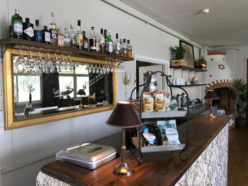 a bar with a mirror and a table with a lamp at Örserumsbrunn Gestgifveri & Konferens in Gränna