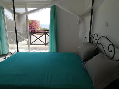 a bedroom with a green bed and a window at Villa Roka - Toubab Dialaw in Toubab Dialaw