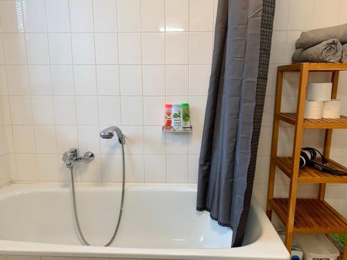 La salle de bains est pourvue d'une baignoire et d'une douche. dans l'établissement Hinterhaus Apartment No3, à Leipzig