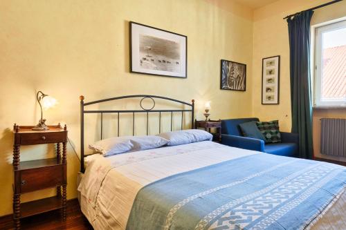 een slaapkamer met een bed, een stoel en een raam bij Central Apartment in Turijn