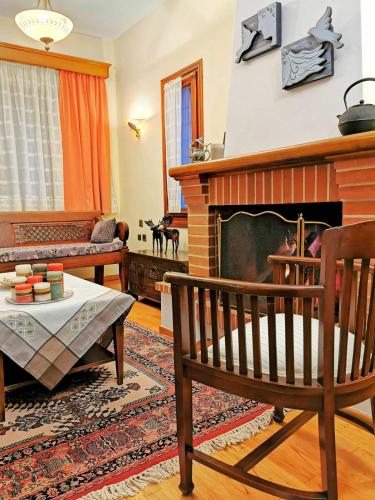 a living room with a fireplace and a couch at Villa Ευορέων in Pertouli
