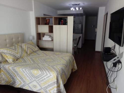 Un dormitorio con una cama y un televisor en una habitación. en San Lorenzo 756, en Rosario