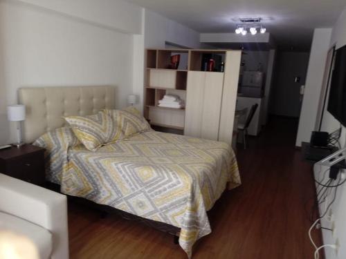 a bedroom with a bed with a comforter at San Lorenzo 756 in Rosario