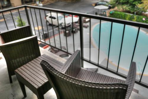 two chairs sitting on a balcony with a swimming pool at River Edge Inn in Gatlinburg