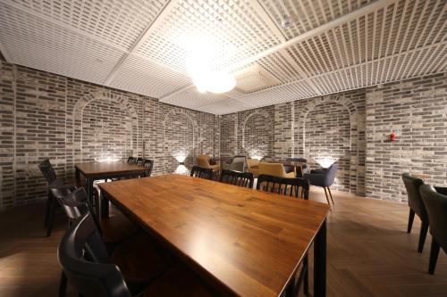 a restaurant with tables and chairs and brick walls at Hotel Noblestay in Daegu