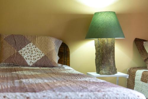 a lamp sitting on a table next to a bed at Calas Lodge in Bajos del Toro