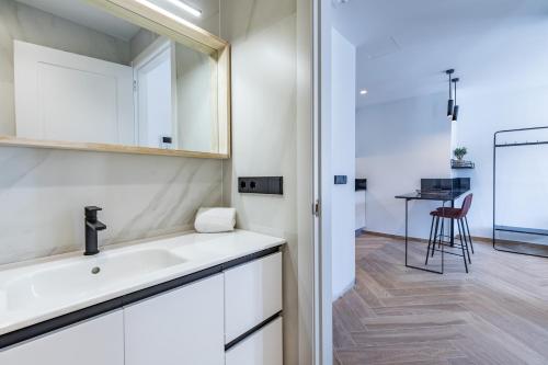 a bathroom with a sink and a mirror and a table at Goerlich by Alma Suites in Valencia