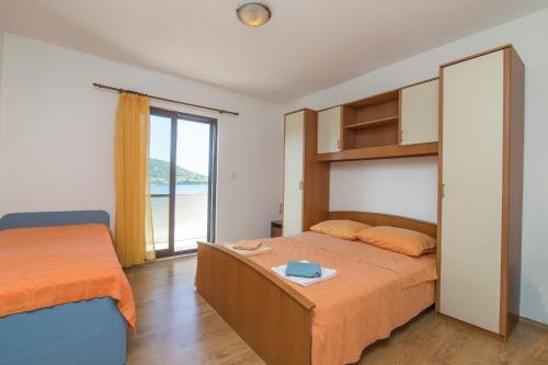1 dormitorio con 2 camas y ventana en Apartment Matea en Ubli