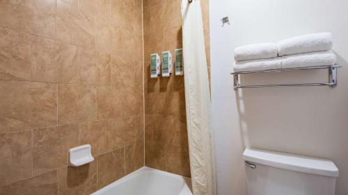 e bagno con servizi igienici, doccia e asciugamani. di Best Western Discovery Inn a Tucumcari