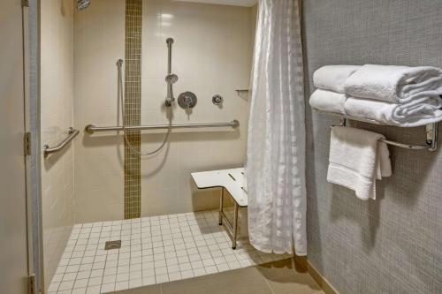 a bathroom with a shower and a sink and towels at Hyatt Place Richmond - Innsbrook in Short Pump