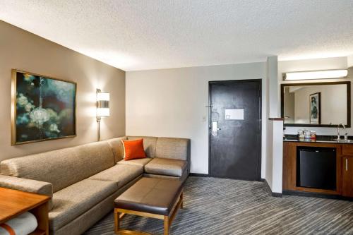 a living room with a couch and a table at Hyatt Place Richmond - Innsbrook in Short Pump