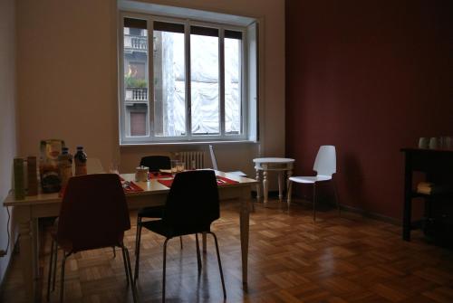 ein Esszimmer mit einem Tisch, Stühlen und einem Fenster in der Unterkunft R&B Errepì Piola in Mailand