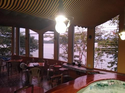 a restaurant with tables and chairs and windows at Boca Brava Lodge in Boca Chica
