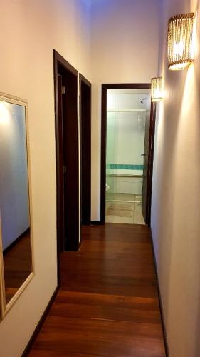 a hallway with two open doors and a mirror at Pousada Paraíso Gaia in Praia do Rosa