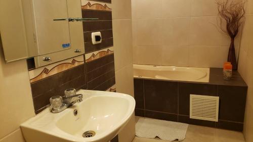 特魯希略的住宿－Hotel Chimor，浴室配有盥洗盆、镜子和浴缸
