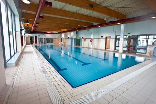 een groot zwembad met blauw water in een gebouw bij Four Seasons Hotel, Carlingford in Carlingford