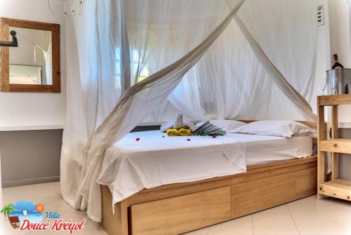 a bedroom with a canopy bed with bananas on it at Villa "Doucè Kréyol" in Le Marin