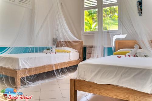 a bedroom with two beds with stuffed animals on them at Villa "Doucè Kréyol" in Le Marin