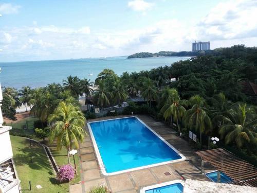 an aerial view of a swimming pool and the ocean at Seri Bulan Condo in Port Dickson