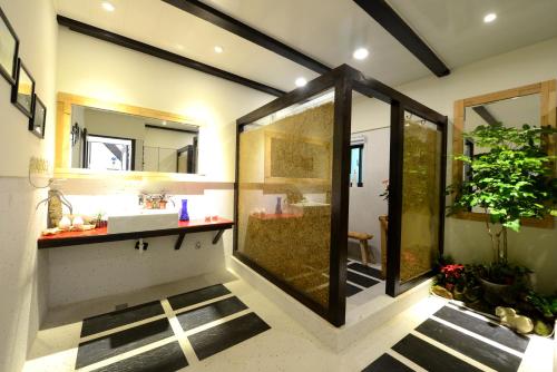 a bathroom with a sink and a shower and a mirror at Windsor's Breeze in Jiufen